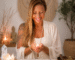 Texto alternativo (ALT TEXT): Taróloga Margarida Fernandes num ambiente espiritual sereno e harmonioso, segurando uma vela acesa durante o Ritual da Lua Crescente em Balança e Solstício de Verão 2026, rodeada por cristais, elementos naturais e energia de equilíbrio, paz interior e reequilíbrio dos caminhos.
