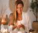 Texto alternativo (ALT TEXT): Taróloga Margarida Fernandes num ambiente espiritual sereno e harmonioso, segurando uma vela acesa durante o Ritual da Lua Crescente em Balança e Solstício de Verão 2026, rodeada por cristais, elementos naturais e energia de equilíbrio, paz interior e reequilíbrio dos caminhos.